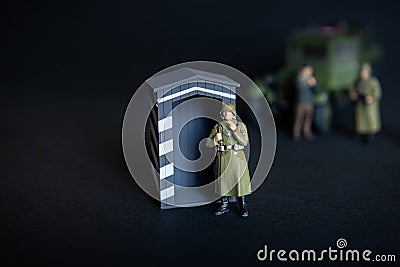 A figure of a man in a military German uniform. In the background of a vague truck Stock Photo