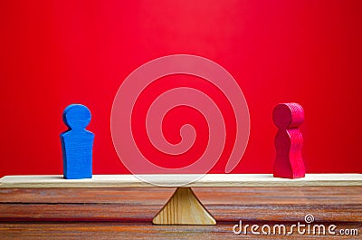 The figure of a man and a woman on scales. Gender pay gap. Equality, inequality. The concept of divorce and division of property. Stock Photo