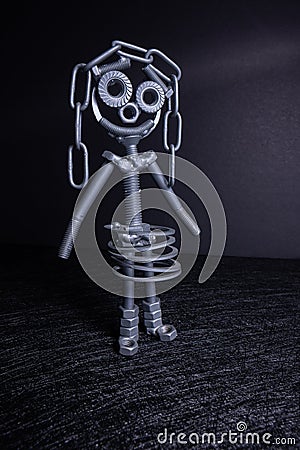 A figure of one small robot assembled from several bolts and nuts standing in a vertical position . It symbolizes technology, Stock Photo