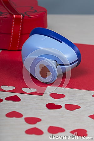 Figured plastic paper punch and handmade red hearts. Stock Photo