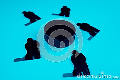 Figures of five hockey players and one puck on a blue background Stock Photo