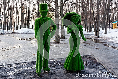 Figures from the grass. Lady and gentleman. Early spring. Stock Photo