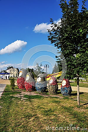 Figures of nesting dolls on the city square. Figures of different heights in a green meadow Editorial Stock Photo