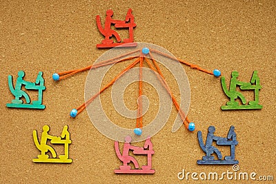 Figures and ropes pinned to the board. Delegation concept. Stock Photo