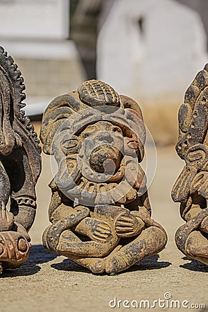 Figures sitting with glass in hand with feathers on their heads Stock Photo