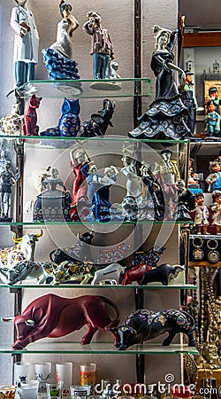 Figures of Spanish bulls, cats, owls and typical Andalusian sevillanas dancing in different colors from a display in a souvenir Stock Photo