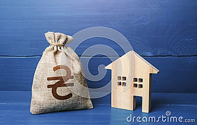 Figurine silhouette house and ukrainian hryvnia money bag. Buying and selling real estate. Mortgage loan. Sale of housing. Stock Photo