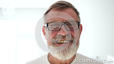 Fijne grootvader met een grijze baard glimlachen en meesters bij de camera Oudere man, dicht portret op een wit stock videobeelden Fijne grootvader met een grijze baard glimlachen en meesters bij de camera Oudere man, dicht portret op een wit stock videobeelden
