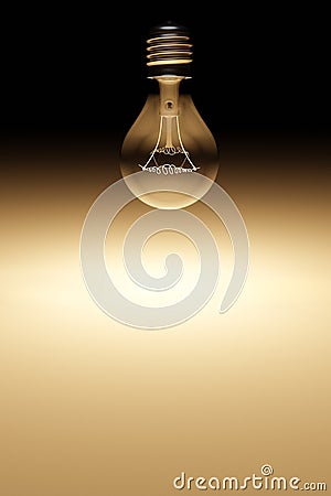 The filament is glowing inside vintage light bulb in dark black background without electrical wire. Stock Photo