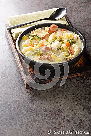 Filipino Chicken Macaroni Soup with vegetables, chicken and elbow pasta close-up on a plate. Vertical Stock Photo