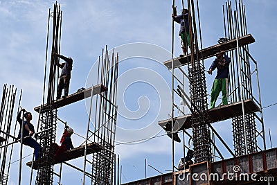 Filipino construction steel-men working joining column steel pieces on board scaffolding pipes on high-rise building Editorial Stock Photo