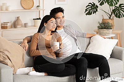 Filipino couple resting at home and watching tv Stock Photo