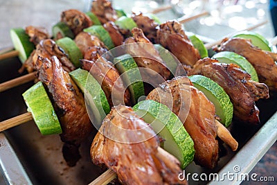 Filipino traditional authentic dish: philippine roasted chicken or pork barbecue on a stick with cucumber Stock Photo