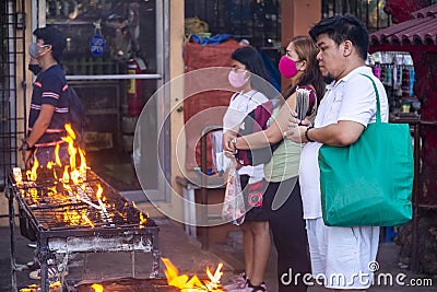 Filipinos gather to pray and light religious candles,at a holy shrine next to the iconic Dumaguete Belfry,that helped save the Editorial Stock Photo