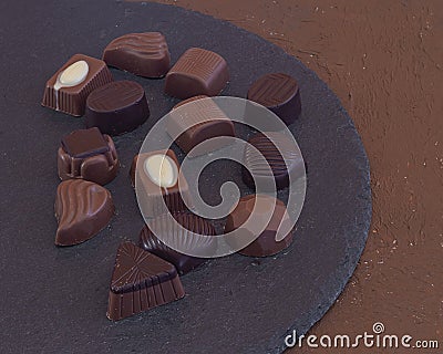 filled chocolate candies various assorted flavors on stone plate Stock Photo