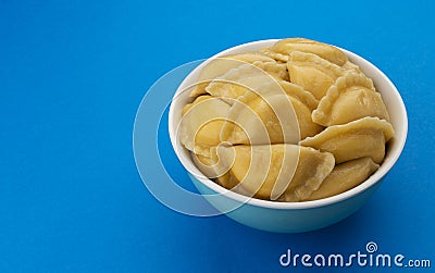 Filled dumplings, russian vareniki, pelmeni on blue background Stock Photo