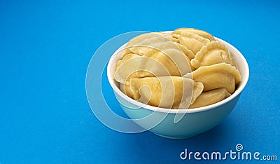 Filled dumplings, russian vareniki, pelmeni on blue background Stock Photo