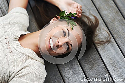 Filled with positive natural energy. An attractive young woman lying on her porch. Stock Photo