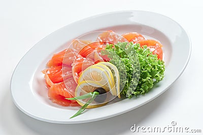 Fillet of red fish on a plate with greens and lemon Stock Photo