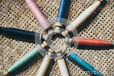 Filling carriers of the loom with woven cloth on background Stock Photo