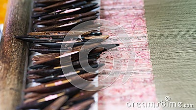 Filling carriers of the loom with woven cloth on background Stock Photo