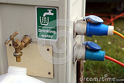 Filling a drinking water container at a campsite water and electricity supply point Stock Photo