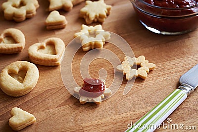Filling homemade Linzer Christmas cookies with red jam Stock Photo