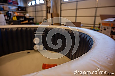 Filling an inflatable indoor hot tub inside a residential garage Stock Photo