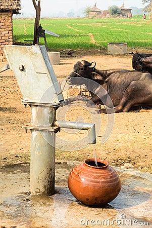 Filling water from Handpump in a village Stock Photo