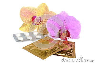 Film-coated tablets and condoms with two orchid flowers isolated Stock Photo