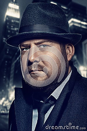 Film noir. Close-up retro style fashion portrait of a detective. A man in a suit against a background of a night city Stock Photo