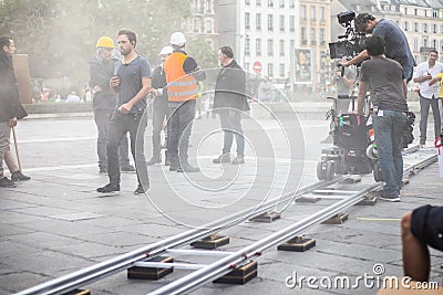 Film set production, near Notre-Dame Cathedral, director, operator, ARRI camera, trolley cart, artificial fog, actors Editorial Stock Photo