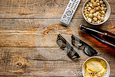 Film whatching party with beer, chips and pop corn wooden background top view mockup Stock Photo