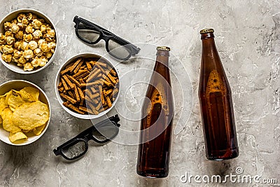 Film whatching party with beer, crumbs, chips and pop corn stone background top view Stock Photo