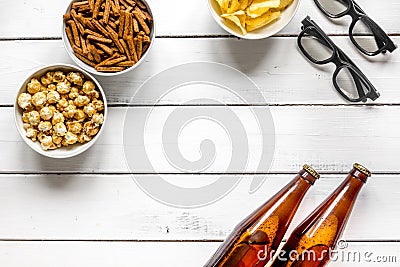 Film whatching party with beer, crumbs, chips and pop corn white wooden background top view mockup Stock Photo