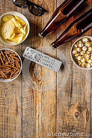 Film whatching party with beer, crumbs, chips and pop corn wooden background top view mockup Stock Photo