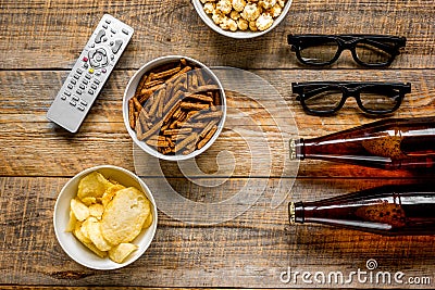 Film whatching party with beer, crumbs, chips and pop corn wooden background top view mockup Stock Photo