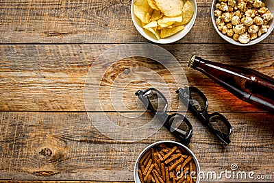 Film whatching party with beer, crumbs, chips and pop corn wooden background top view mockup Stock Photo