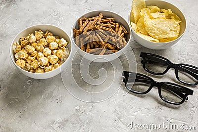 film whatching party with glasses, crumbs, chips and pop corn stone background Stock Photo