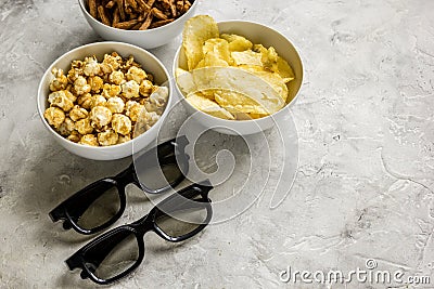 Film whatching party with glasses, crumbs, chips and pop corn stone background mockup Stock Photo