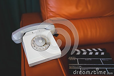 Filming some cinema movie..Vintage Brown leather armchair in loft design apartment..Old retro landline phone, sunglasses and Stock Photo