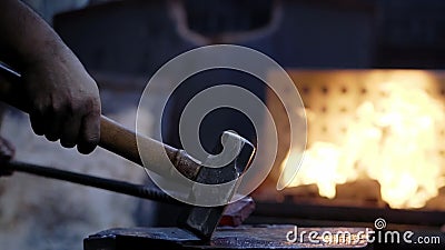 Filmstijl van een smid met trage beweging die een heet ijzer smeedt in het smeedijzer. vakmanschap in antieke werken stock footage Filmstijl van een smid met trage beweging die een heet ijzer smeedt in het smeedijzer. vakmanschap in antieke werken stock footage