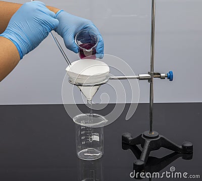 Filter paper in laboratory. Scientists are chemical filtration by filtering through filter paper in a glass funnel, Close up. Phar Stock Photo