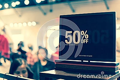 Filtered image 50 percent off sale sign over clothes at department store with customer shopping Editorial Stock Photo