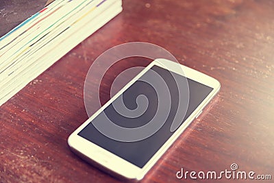 Filters vintage smartphone and book on a wooden table Stock Photo