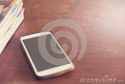 Filters vintage smartphone and book on a wooden table Stock Photo