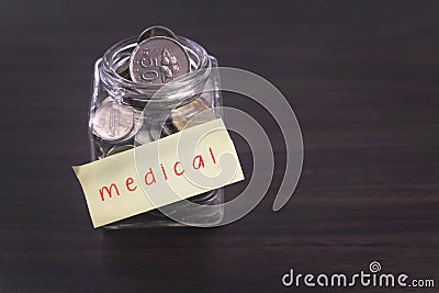 Finacial concept. Money in the glass on wooden table with Medical word Stock Photo