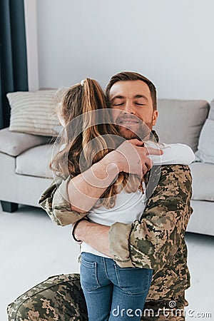 Finally at home. Soldier in uniform is with his little daughter Stock Photo