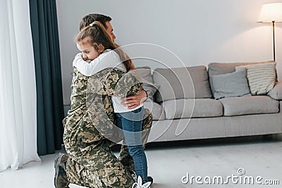 Finally meet each other. Soldier in uniform is at home with his little daughter Stock Photo
