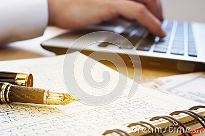 Financial accounting. Accountant work on a laptop and ledger. Stock Photo